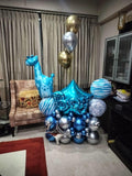 Blue giraffe and BABY letter balloons arranged on a navy and silver balloon base.