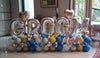 Silver GROOM balloon letters with personalised hearts, rose gold LOVE lettering and blue, gold, white and silver balloons placed indoor.