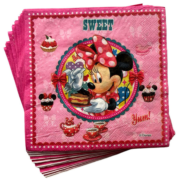 Folded pink Minnie Mouse napkins showing the character, a birthday cake and decorative border details for a child's themed party table.