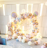 Pastel baby arrival balloon ring with butterfly accents, confetti balloons, gold stars and BABY boxes.