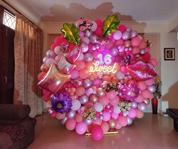 Sweet 16 home balloon decoration in Gurgaon with pink balloons, floral accents and neon birthday backdrop by Funzoop