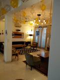 Gold and silver ceiling balloons with hanging photographs in a living room.