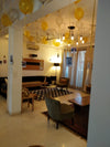 Gold and silver ceiling balloons with hanging photographs in a living room.