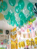 Green and white helium balloons styled as a ceiling display, done by Funzoop Party Store