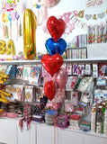 Red, blue and pink heart-shaped foil balloons displayed as a helium bouquet delivered by Funzoop Party Store