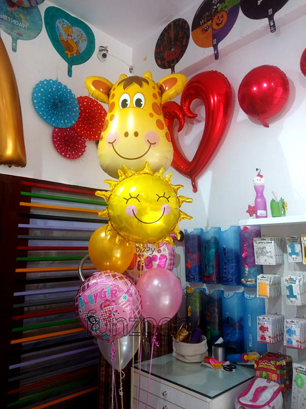 Giraffe Baby Girl Smiley Sunflower Balloons Bouquet shown in a styling reference for garden, tropical and summer celebrations, with extra decorations separate from this listing.