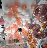 White and rose gold metallic helium balloons arranged across a ceiling, done by Funzoop Party Store